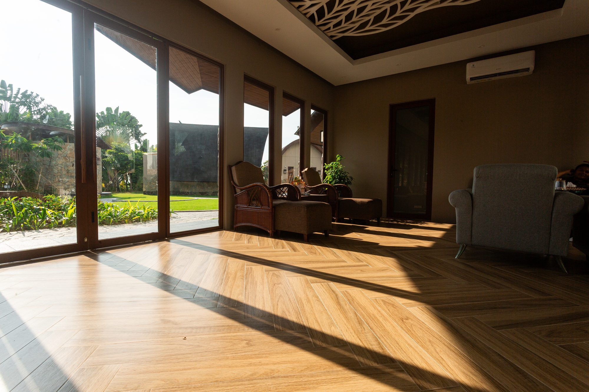 Lounge seating beside floor-to-ceiling glass opening onto the village lawn