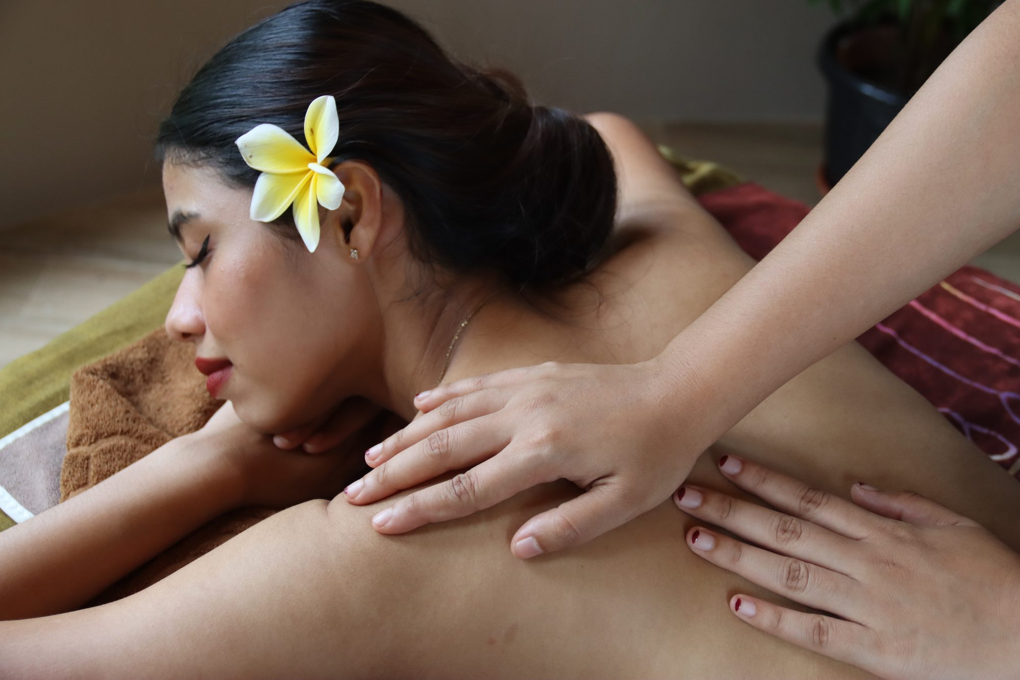 A therapist's hands working across a guest's shoulders during a Balinese massage
