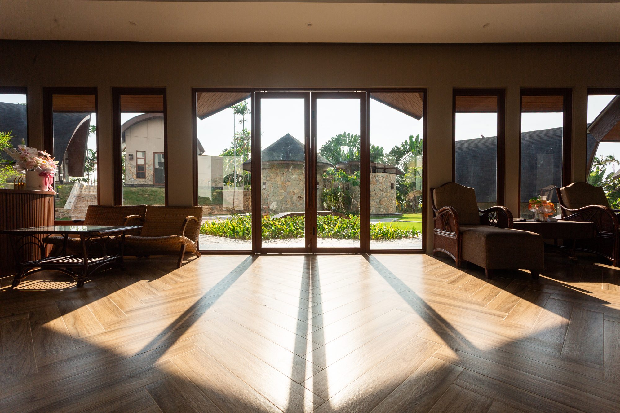 The wellness pavilion lobby, with late afternoon light falling across a herringbone timber floor