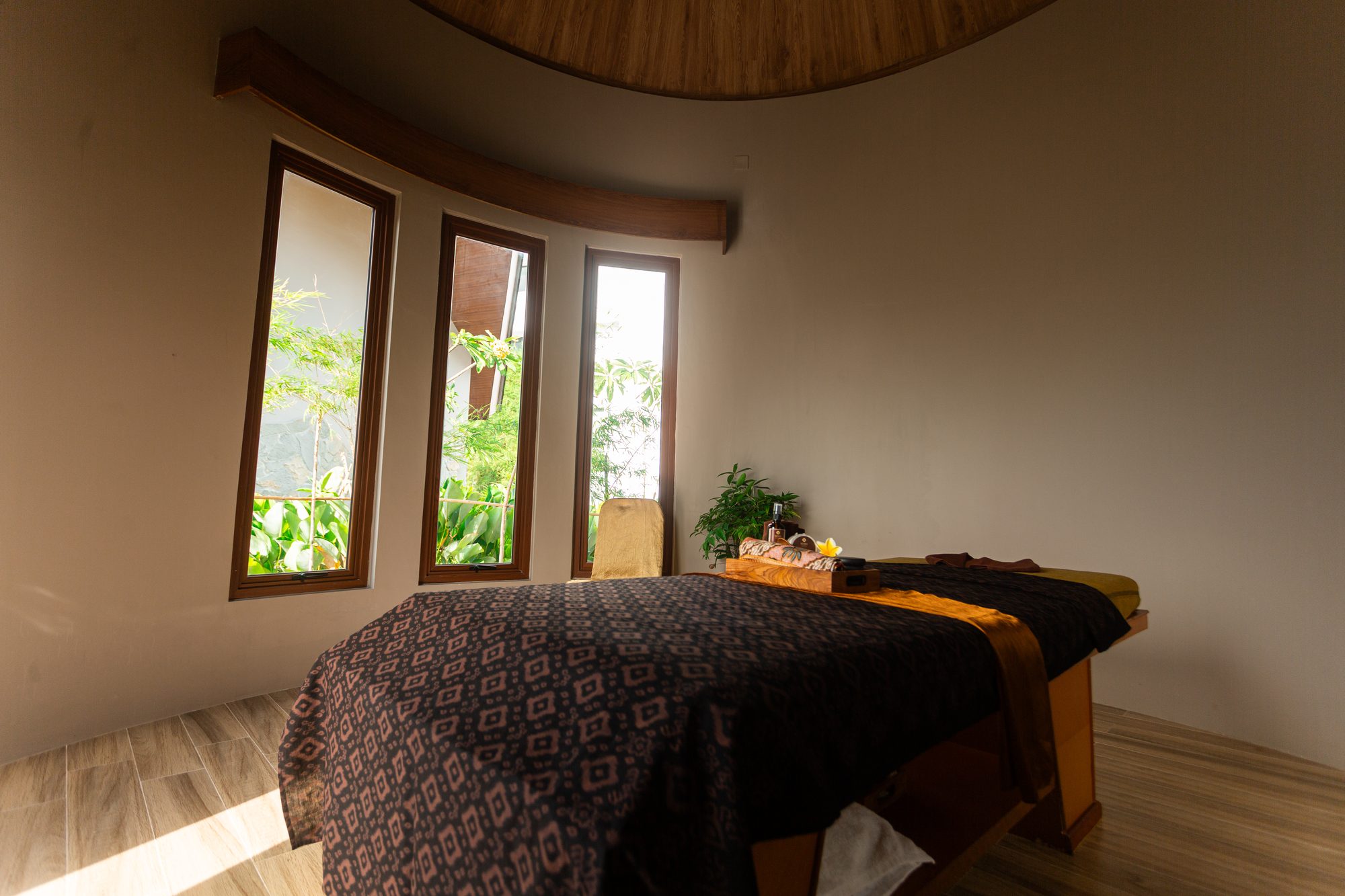 A private treatment room with curved windows and a domed timber ceiling