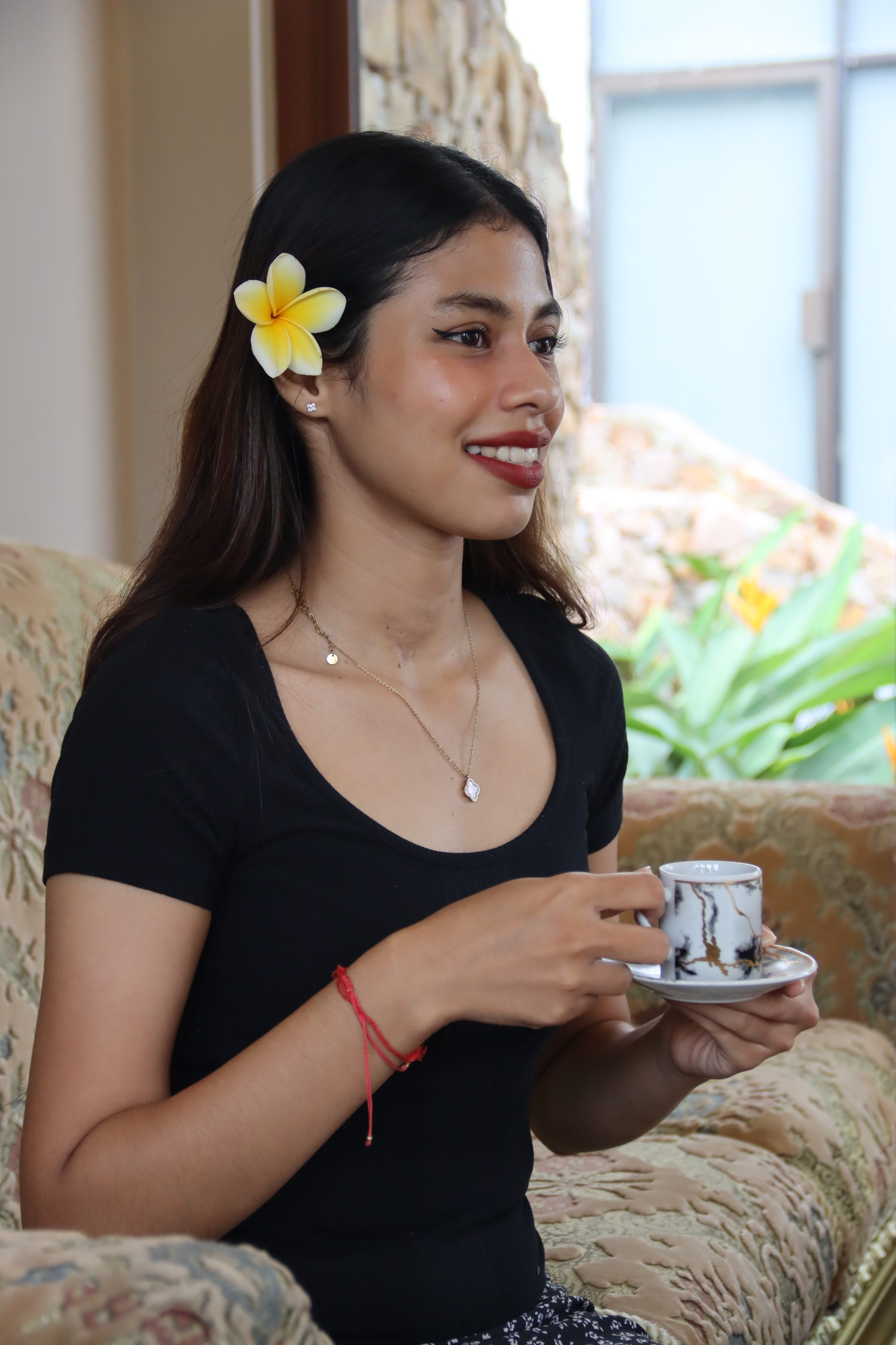 A guest in the lounge holding a cup of welcome herbal tea
